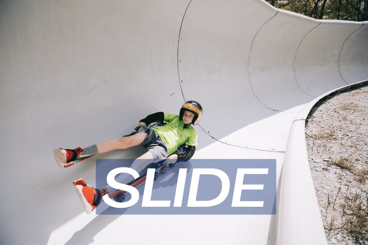 boy sliding on wheel luge track for adventure in the summer
