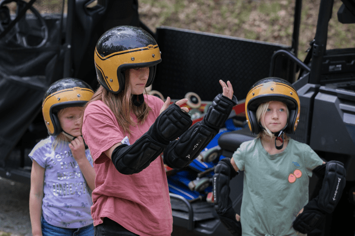 Three girls get safety equipment to learn to wheel luge