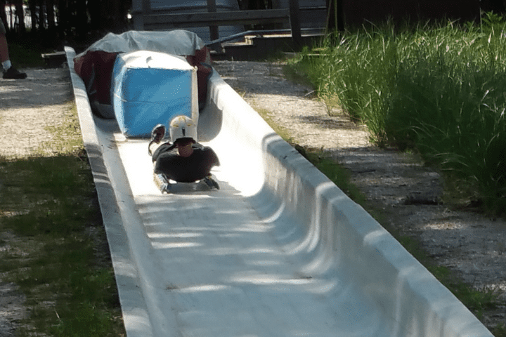 person stopping on wheel luge sled