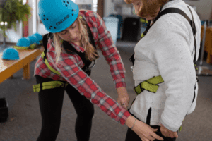 Female zip line guide tightens harness