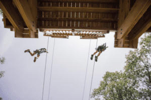 two people jumping off zip line platform