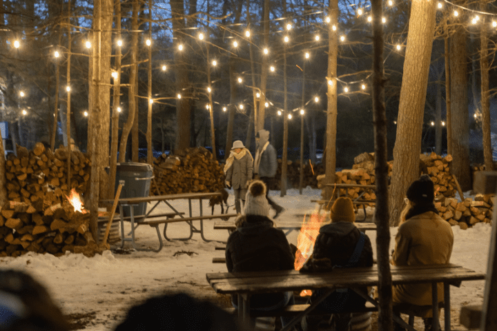 people sitting around winter bonfire