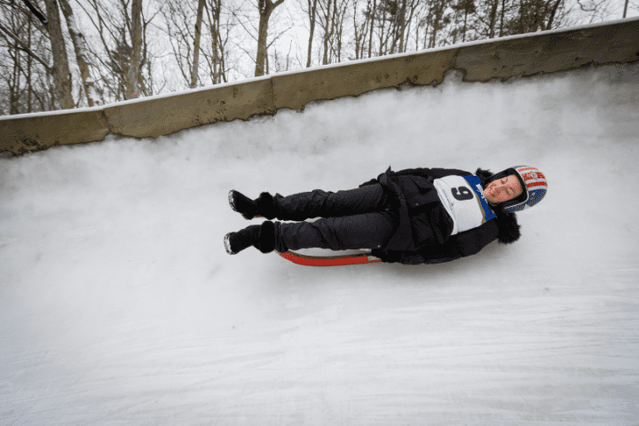woman on luge sled sliding on ice